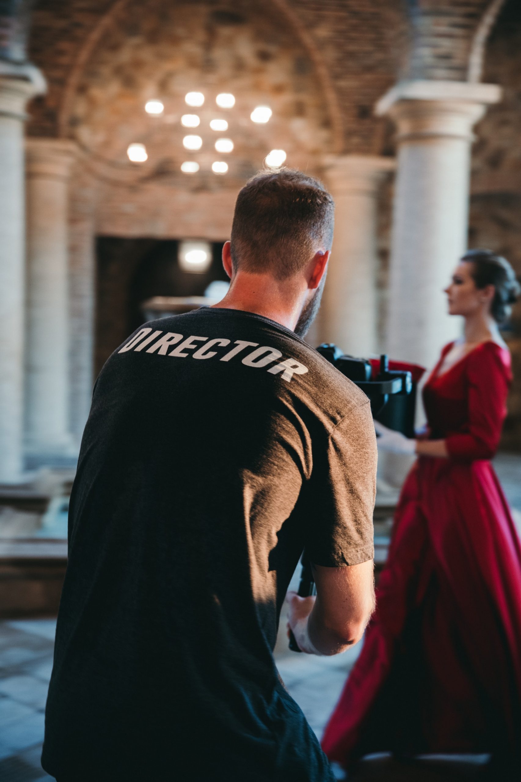 A director filming a woman in a red dress